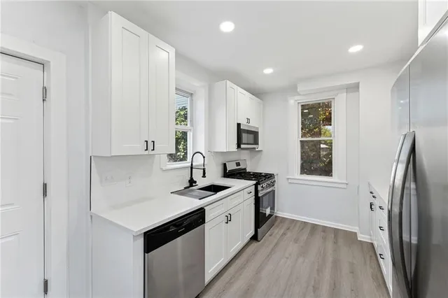 a kitchen with stainless steel appliances granite countertop a sink stove and refrigerator
