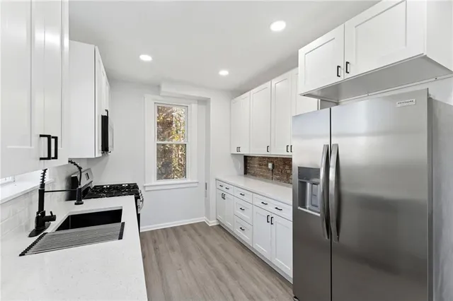a kitchen with granite countertop a refrigerator and a sink