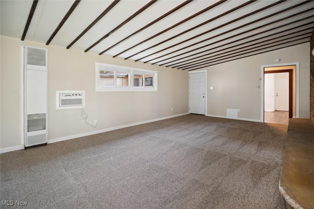6683 Sherborn Road Cleveland, OH 44130 - Photo 21 of 42 Carpeted spare room featuring vaulted ceiling with beams and an AC wall unit