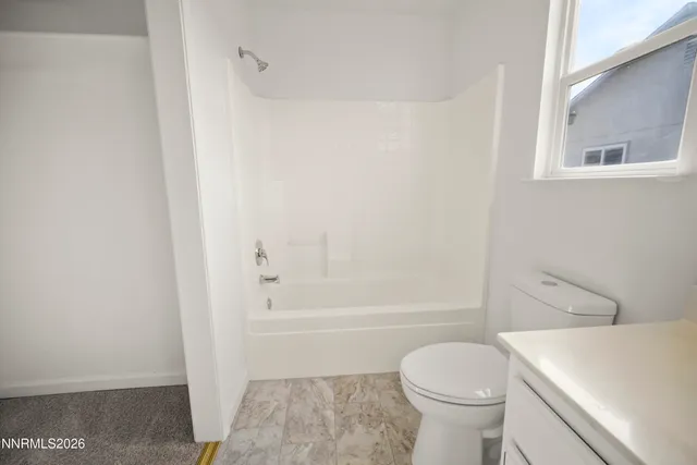 a bathroom with a toilet and a bath tub