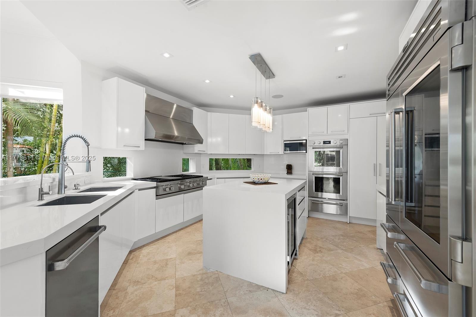 455 Centre Island Golden Beach, FL 33160 - Photo 26 of 67 a kitchen with stainless steel appliances granite countertop a sink stove and refrigerator