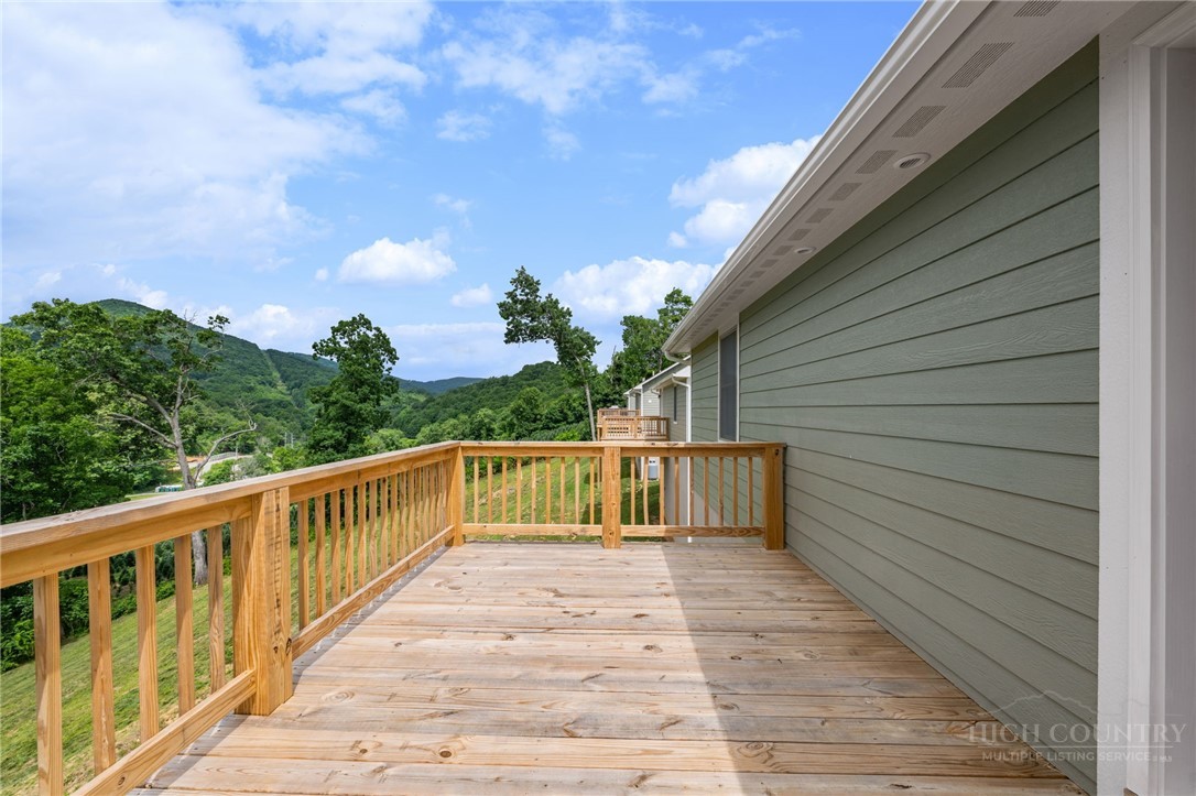 233 Ava Way, Unit 109 Boone, NC 28607 - Photo 6 of 27 a balcony with wooden floor and fence