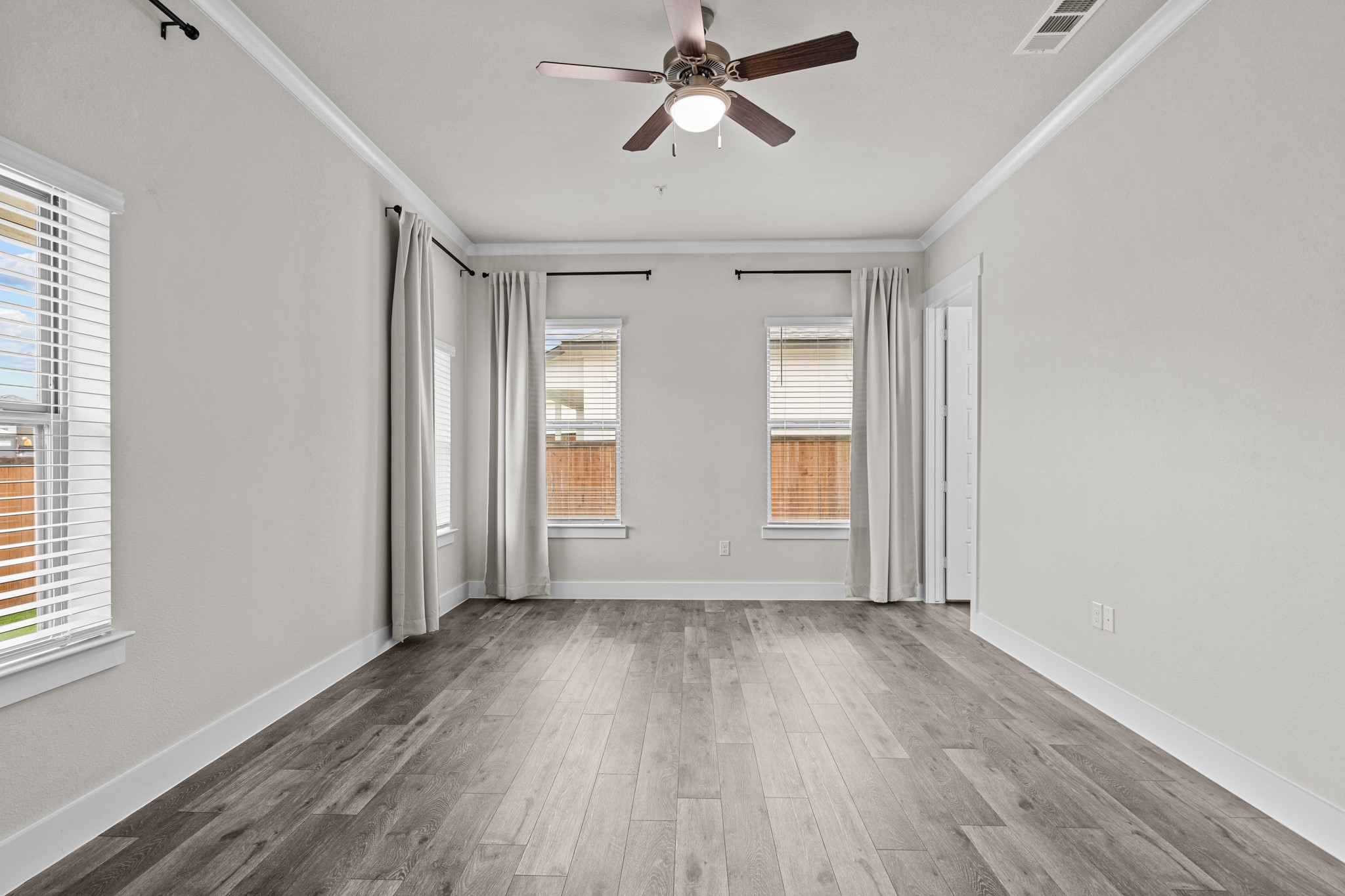 865 Limmer Loop, Unit 811 Hutto, TX 78634 - Photo 28 of 37 a view of empty room with wooden floor and fan