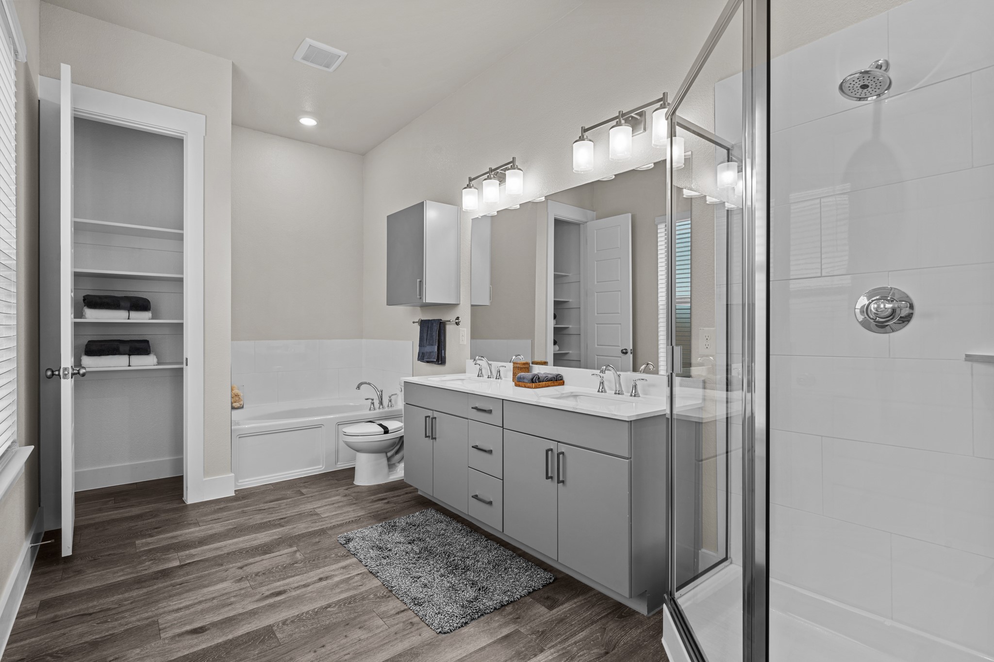 865 Limmer Loop, Unit 811 Hutto, TX 78634 - Photo 31 of 37 a bathroom with a double vanity sink toilet mirror and bathtub