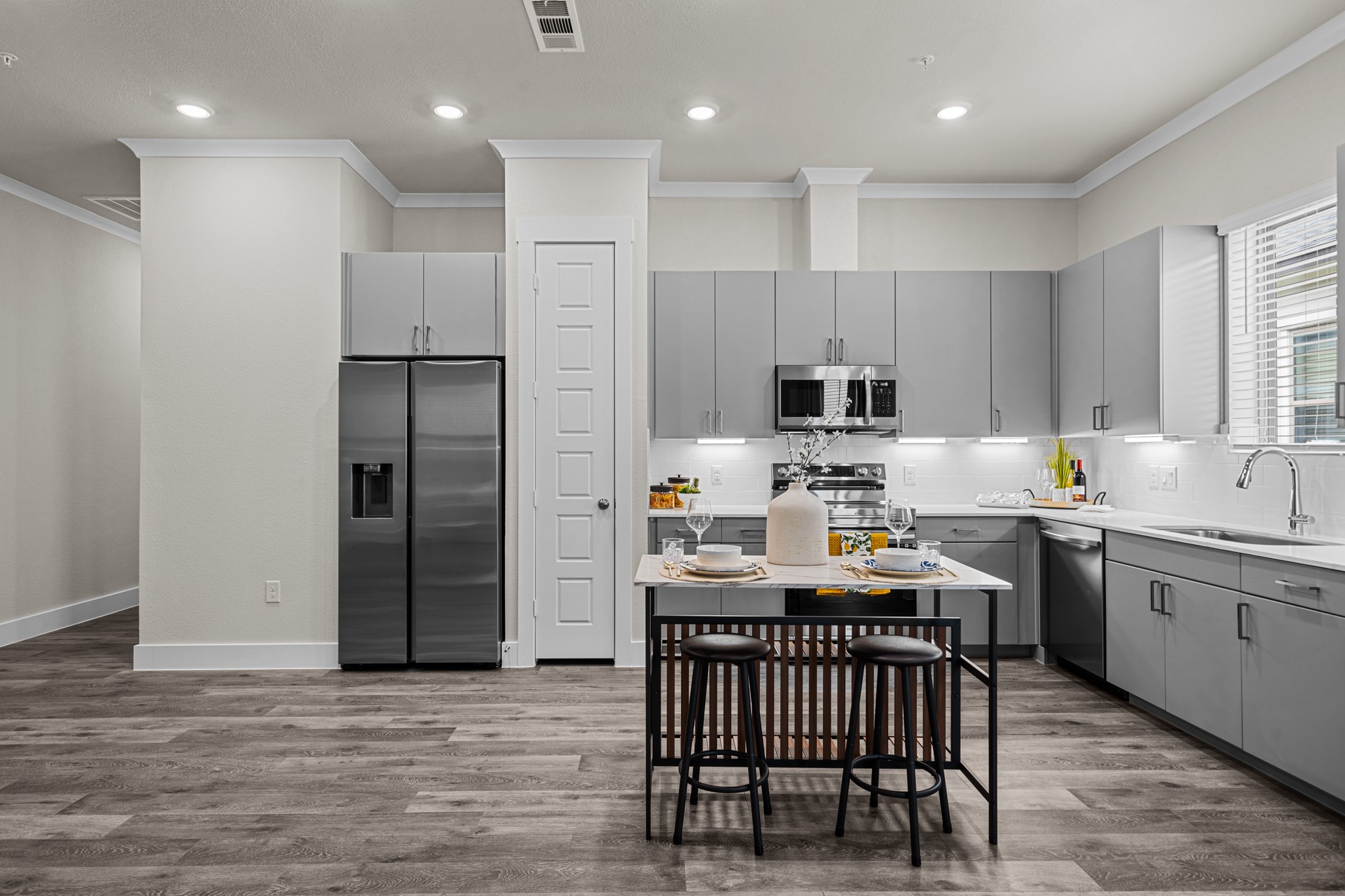 865 Limmer Loop, Unit 811 Hutto, TX 78634 - Photo 7 of 37 a kitchen with stainless steel appliances granite countertop a table chairs sink refrigerator and cabinets