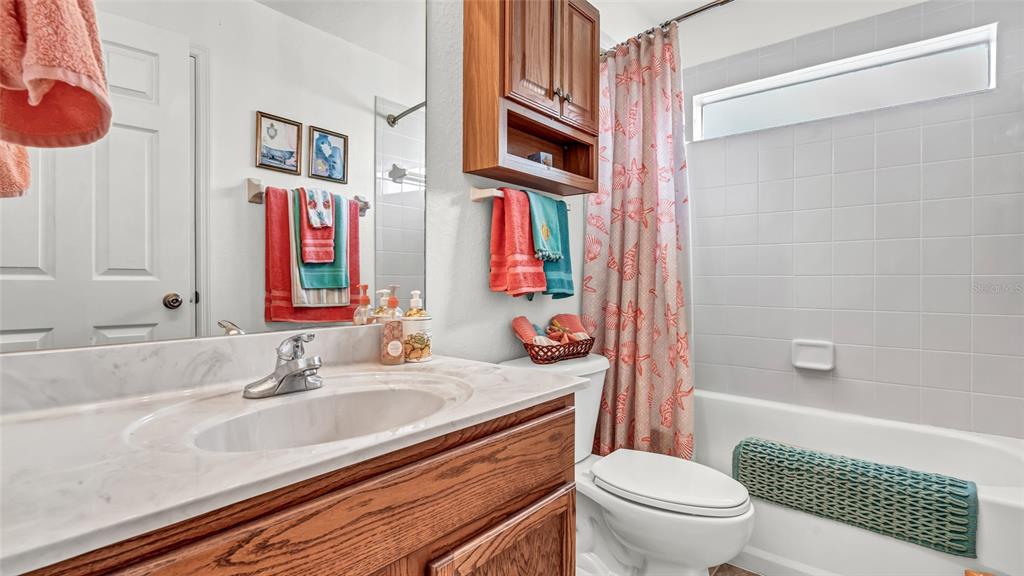 1153 Legatto Loop Dundee, FL 33838 - Photo 29 of 48 a bathroom with a sink a toilet and shower curtain