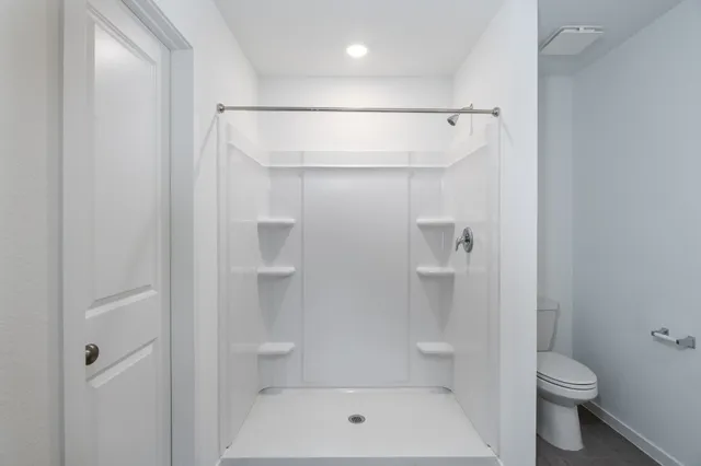 a bathroom with a toilet and a shower
