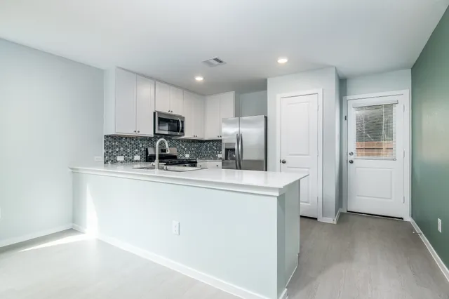 a kitchen with stainless steel appliances granite countertop a refrigerator stove microwave and sink