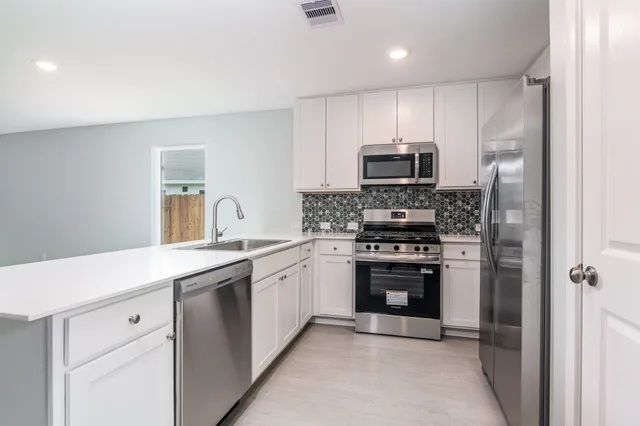 a kitchen with stainless steel appliances granite countertop a stove and a refrigerator
