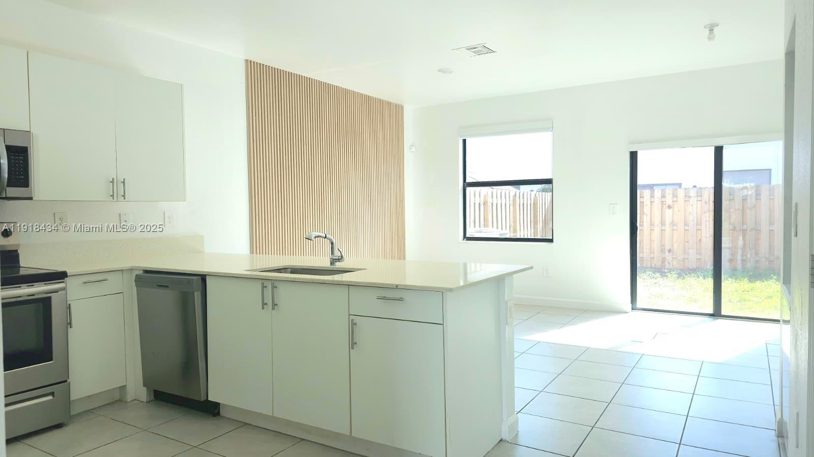 11774 Southwest 246th Street, Unit 11774 Homestead, FL 33032 - Photo 4 of 18 a spacious bathroom with a granite countertop sink a mirror and a bathtub
