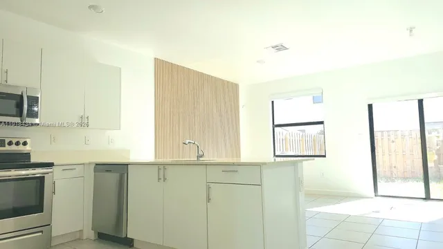 a kitchen with a sink cabinets and a window