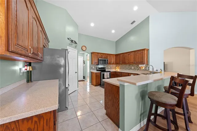 a kitchen with stainless steel appliances granite countertop wooden cabinets a stove top oven a sink and dishwasher