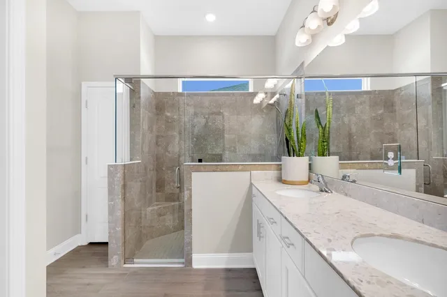 a bathroom with a granite countertop sink a mirror and shower