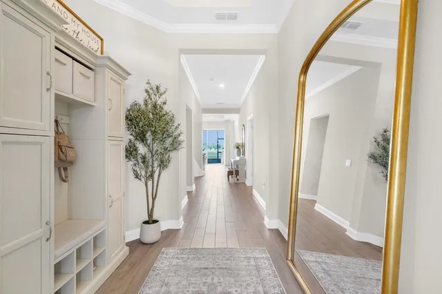 a view of a hallway with wooden floor and a living room