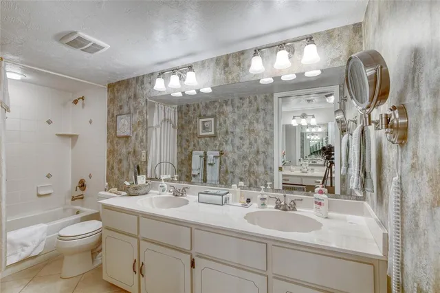 a bathroom with a double vanity sink mirror and toilet