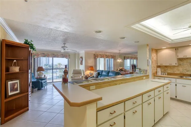 a view of a kitchen with kitchen island a large counter top space a sink stainless steel appliances and cabinets