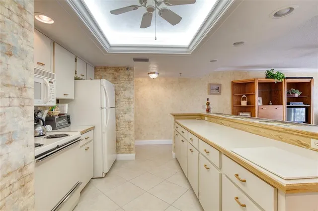 a large white kitchen with stainless steel appliances granite countertop a sink and cabinets