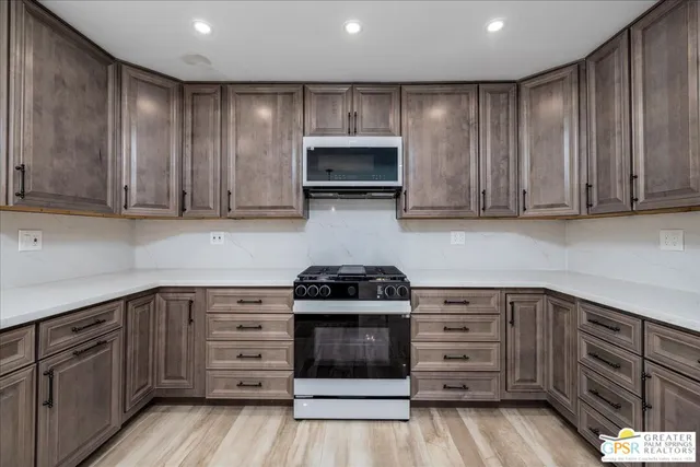 a kitchen with granite countertop a stove and cabinets