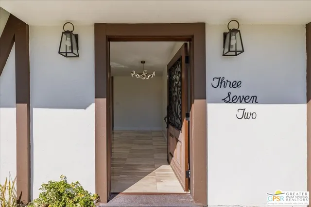 a hallway with a white cabinet a rug and a mirror