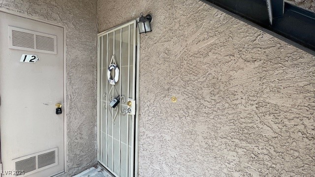 Entrance to property with stucco siding