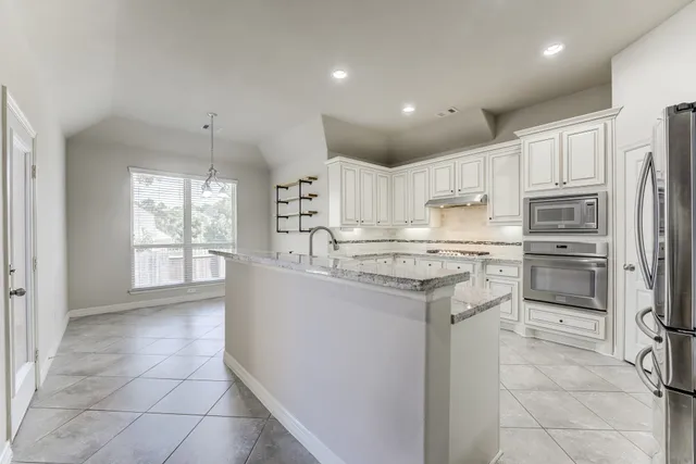 a kitchen with stainless steel appliances granite countertop a refrigerator sink and cabinets