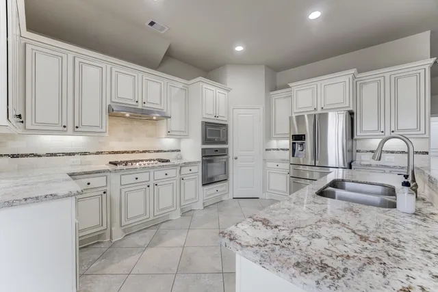 a kitchen with stainless steel appliances granite countertop a refrigerator sink and cabinets