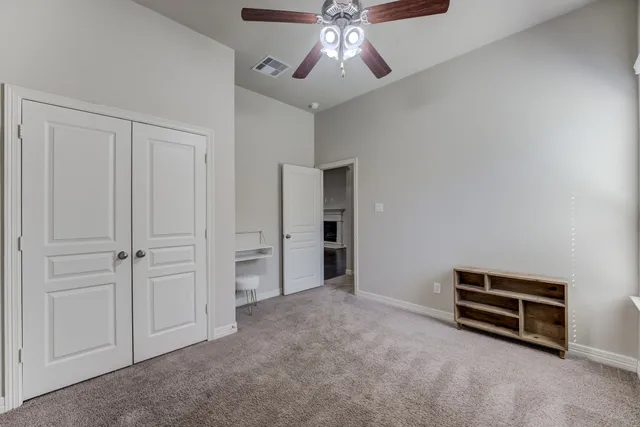a view of an empty room with a ceiling fan