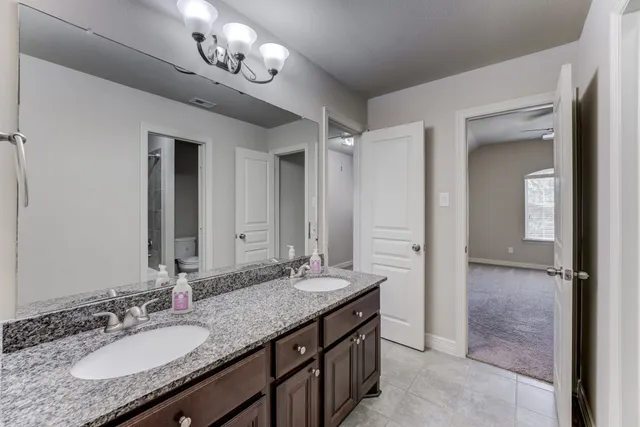a bathroom with a granite countertop sink a large mirror and a shower