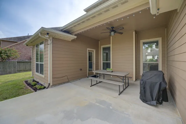 a backyard of a house with barbeque oven table and chairs