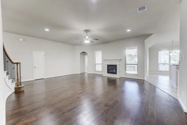 an empty room with wooden floor and fireplace