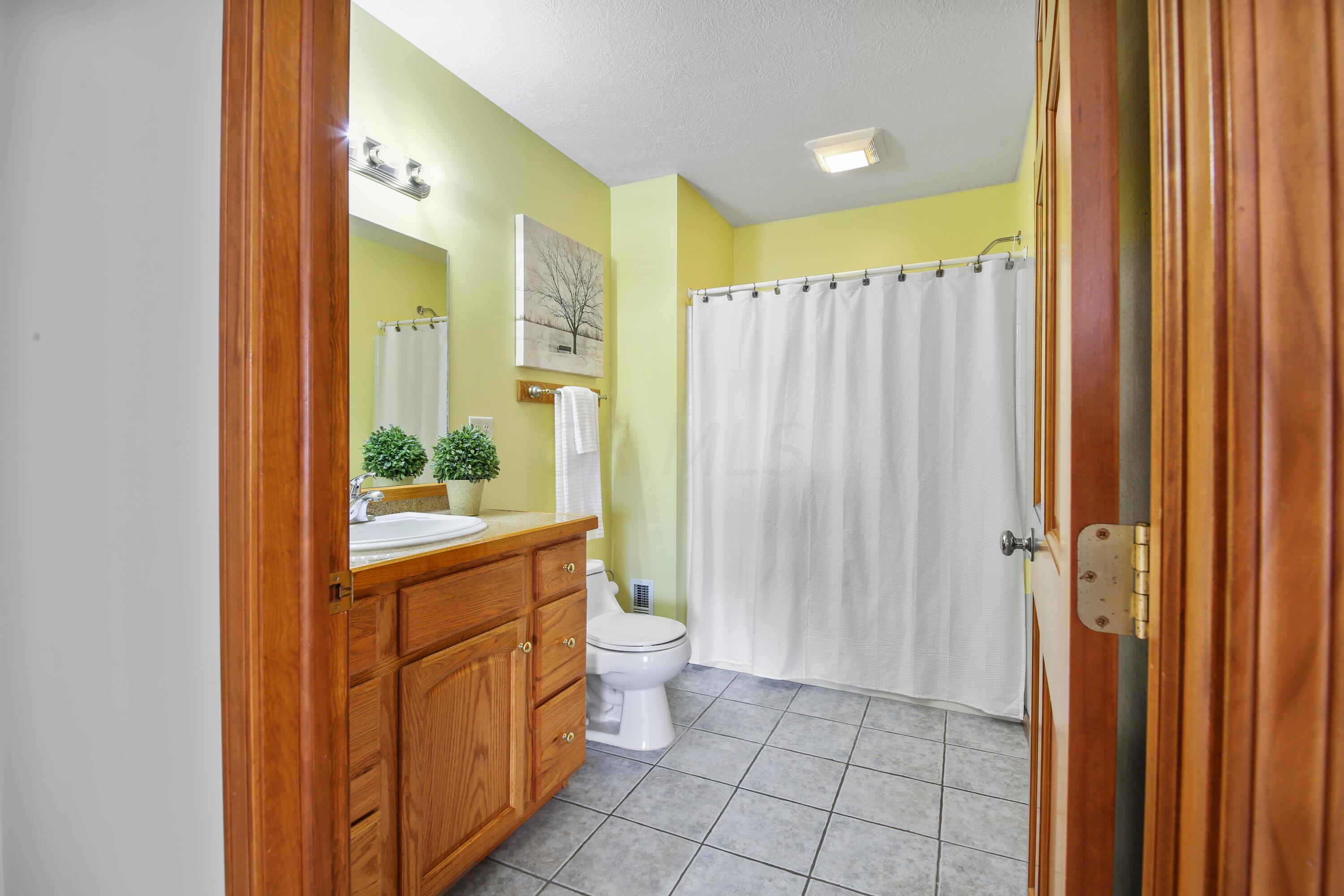 3273 Gooding Road Marion, OH 43302 - Photo 43 of 60 Hall Full Bath features tile flooring, wood cabinetry, granite countertops, tub shower combination, access to the 2nd story laundry area.