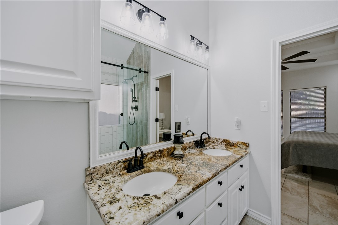 337 Wright Drive Portland, TX 78374 - Photo 14 of 30 a bathroom with a granite countertop sink a mirror and a shower
