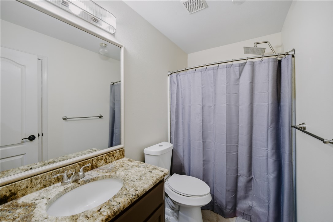 337 Wright Drive Portland, TX 78374 - Photo 19 of 30 a bathroom with a granite countertop sink toilet and shower