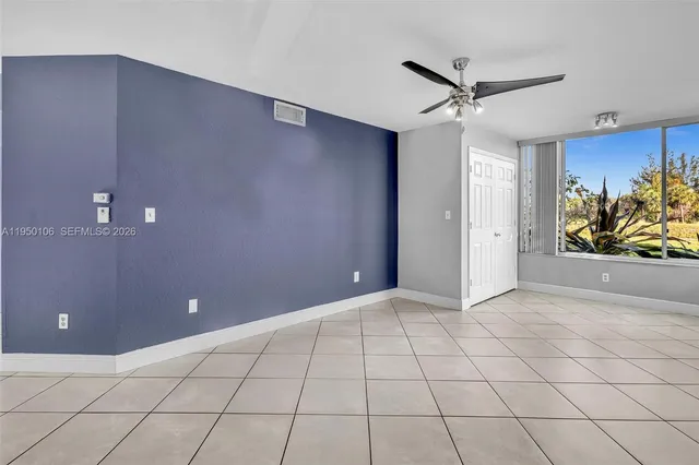 a view of a livingroom with a chandelier fan and windows