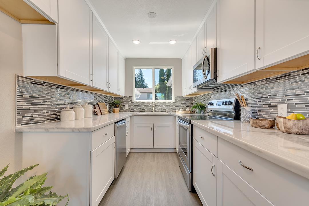 a kitchen with granite countertop cabinets stainless steel appliances a sink and window