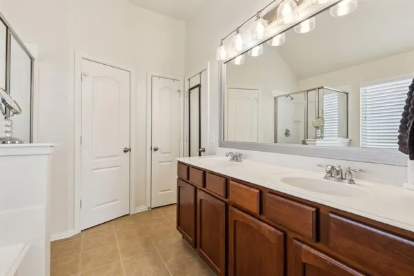 a spacious bathroom with a double vanity sink and mirror