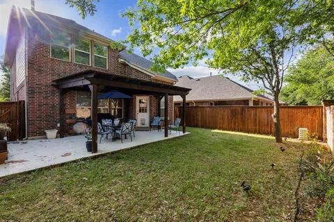 a view of a backyard with table and chairs under an umbrella
