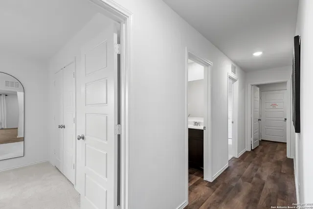 a view of a hallway with wooden floor and staircase