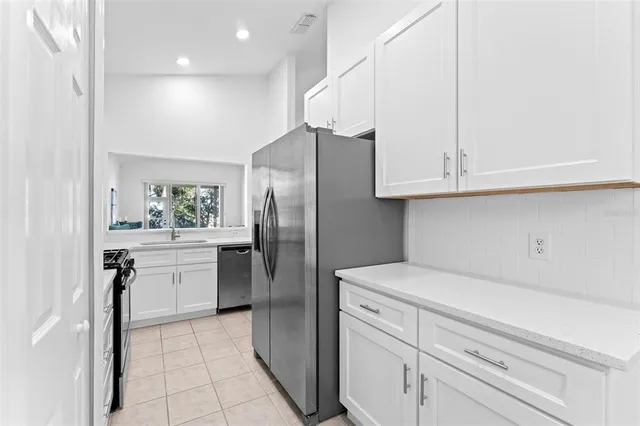 a kitchen with stainless steel appliances granite countertop a sink a stove and a refrigerator