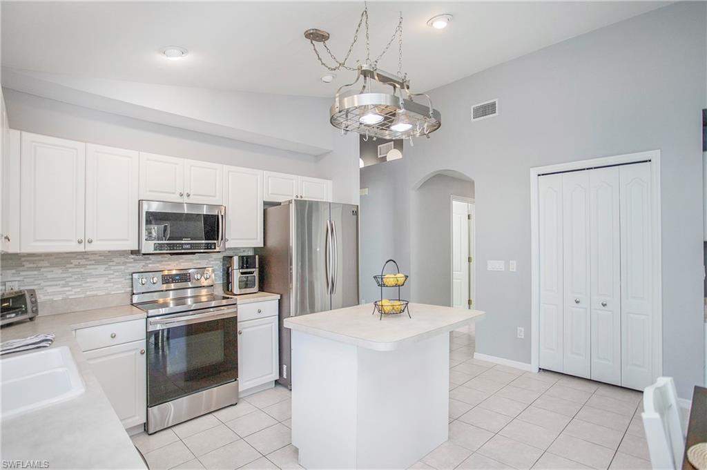 21722 Windham Run Estero, FL 33928 - Photo 12 of 40 a kitchen with stainless steel appliances a stove oven and a refrigerator