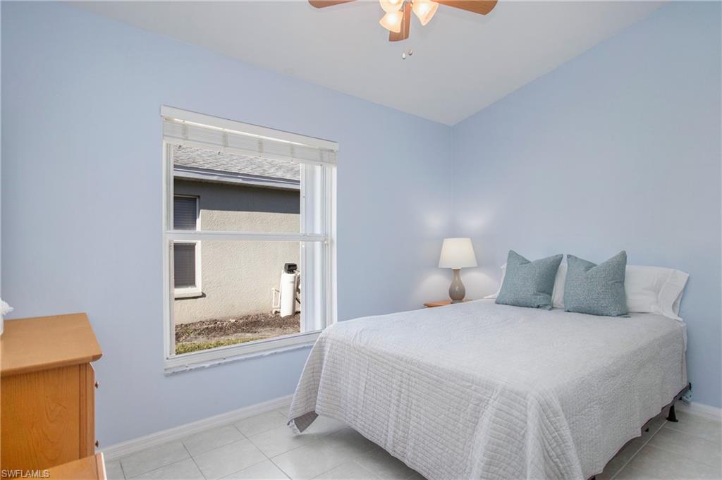 21722 Windham Run Estero, FL 33928 - Photo 16 of 40 a bedroom with a bed and a chandelier