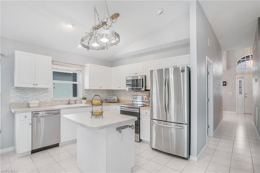 21722 Windham Run Estero, FL 33928 - Photo 2 of 40 a kitchen with a sink stainless steel appliances and cabinets