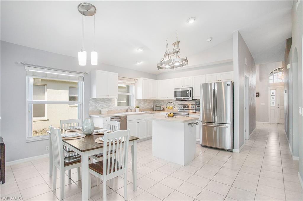 21722 Windham Run Estero, FL 33928 - Photo 10 of 40 a kitchen with stainless steel appliances a refrigerator a stove a dining table and chairs