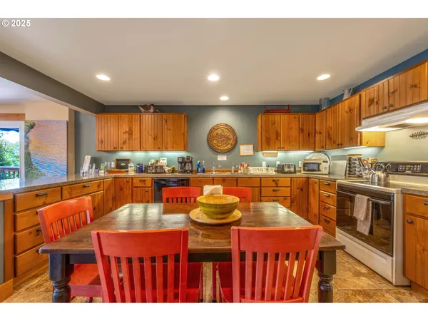 a kitchen with stainless steel appliances granite countertop a kitchen island stools a stove a sink dish washer and a dining table