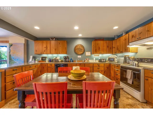 a kitchen with stainless steel appliances granite countertop a kitchen island stools a stove a sink dish washer and a dining table