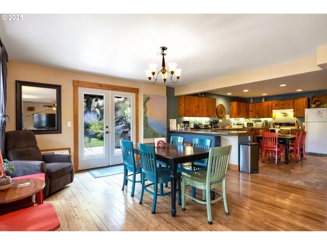 a dining room with furniture a chandelier and wooden floor