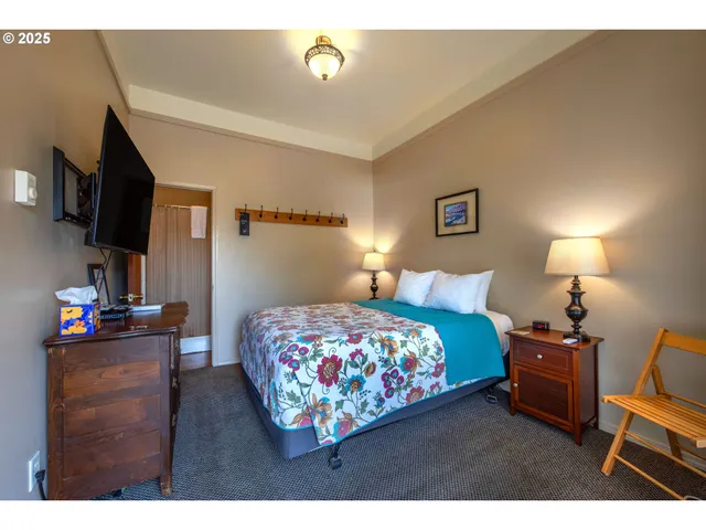 a bedroom with a bed window and a flat screen tv