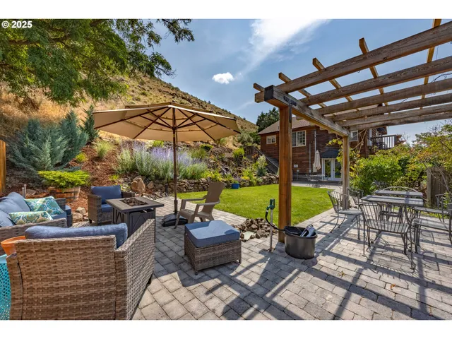 a view of a patio with a table and chairs under an umbrella