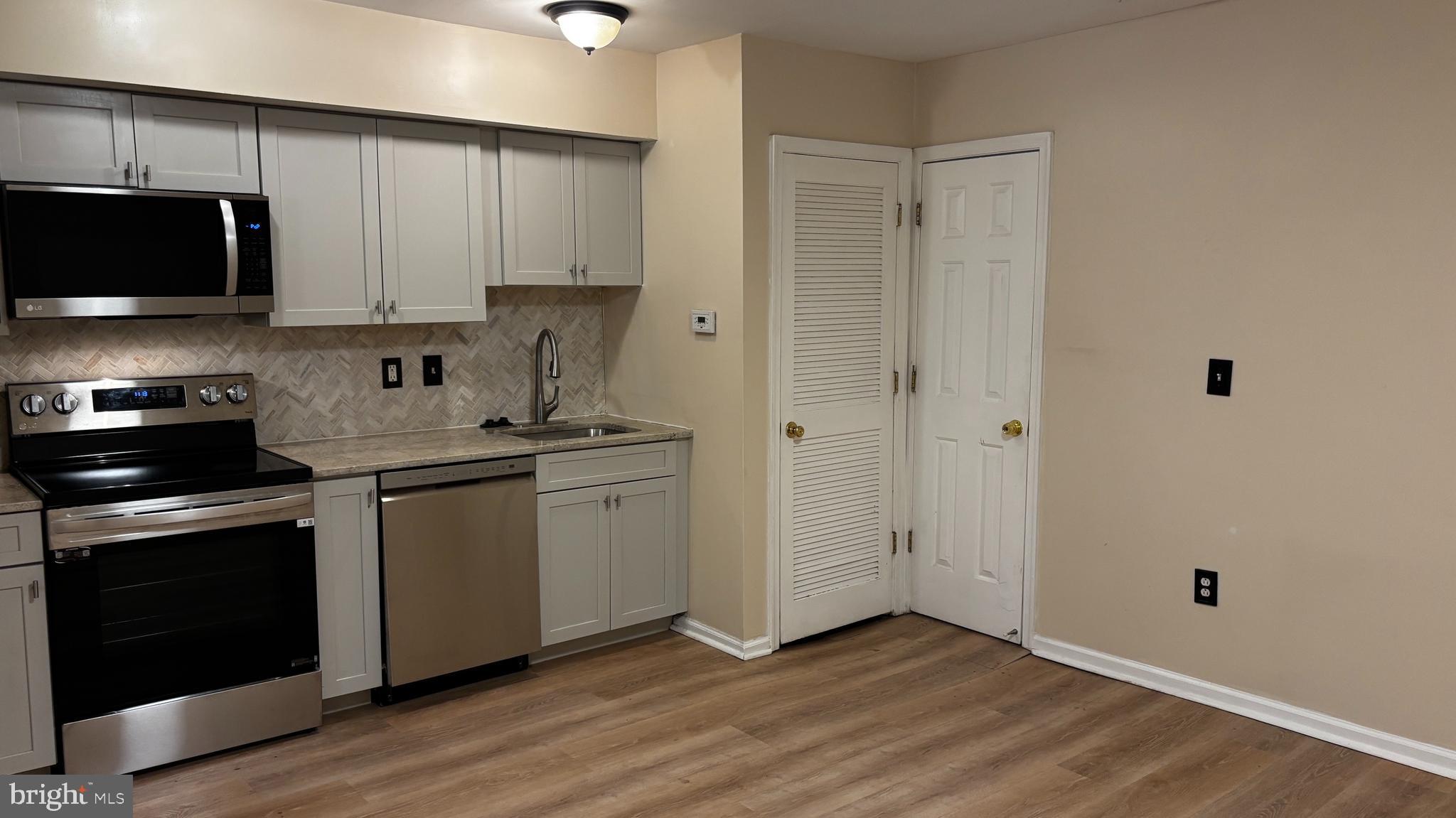 1240 18th Street Northeast, Unit 2 Washington, DC 20002 - Photo 3 of 11 a kitchen with a sink and a stove top oven