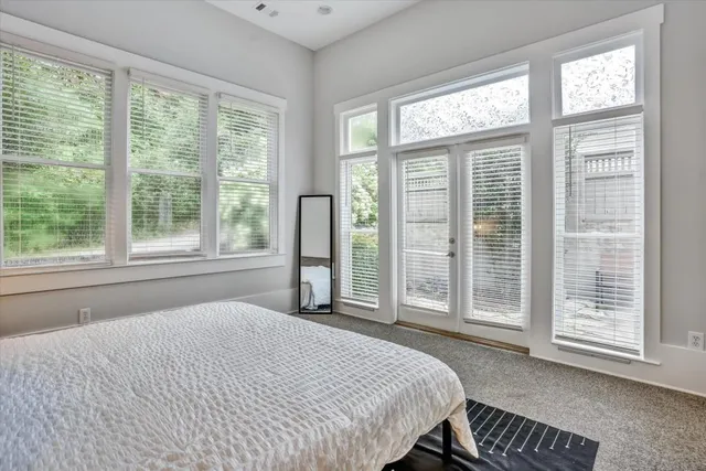 a bedroom with a bed and a large window